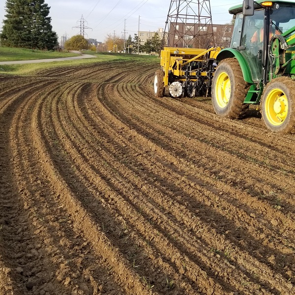 a tractor tills soil in The Meadoway